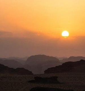 západ slunce v poušti se sluncem na obloze