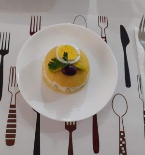 桌子上放着一个白色的盘子,上面放着甜点,还有叉子