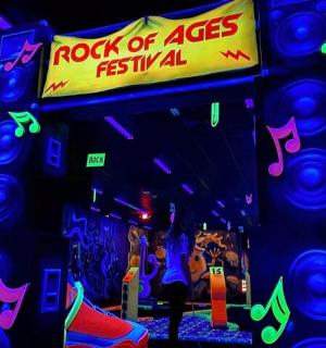 a room with a rock of ages festival sign and lights