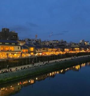 a group of people walking along a river at night