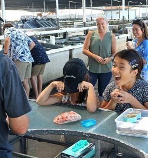 a group of people standing around a table with a man