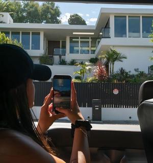 一位女士坐在车里看手机