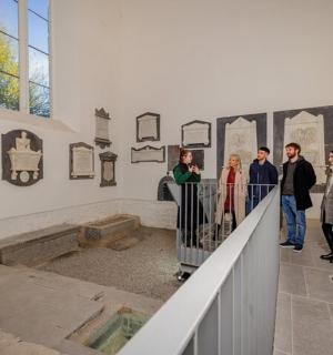 skupina lidí prohlížejících si muzejní exponát