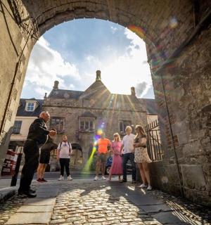 skupina lidí procházejících obloukem