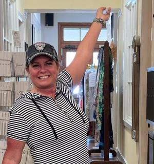 Žena stojí v obchodě se zdviženou rukou