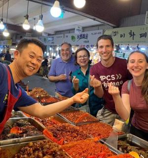 a group of people standing in a market selling food