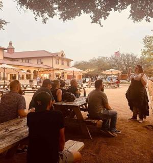 a group of people sitting at picnic tables in a park