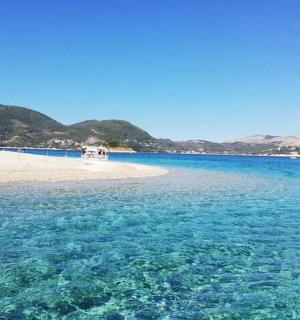 a beach with blue water and mountains in the background