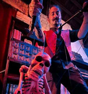 en mand stående i et rum med et skelet