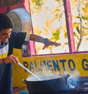 a man cooking in a pot on a table