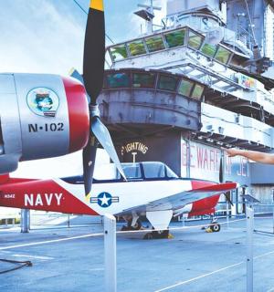 muž stojící vedle malého letadla na lodi