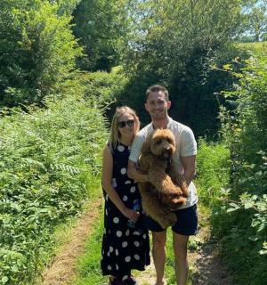 muž a žena držící psa na cestě