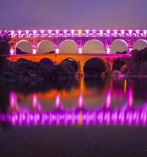 a lit up bridge over a body of water at night