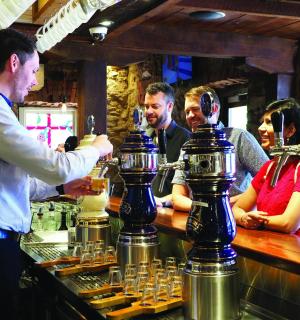 a man standing at a bar making drinks