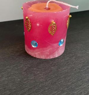 a pink candle sitting on top of a table