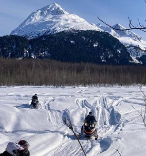 a group of people riding down a snow covered slope