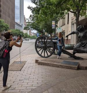 žena fotografující sochu