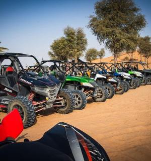 一排全地形车和摩托车停在沙漠中