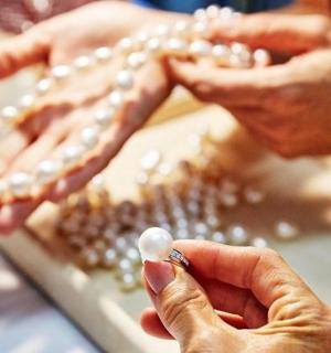 一个人拿着桌子上的珍珠项链