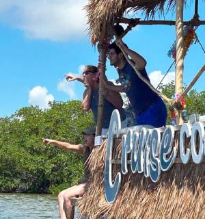 two people sitting on a sign on a boat in the water
