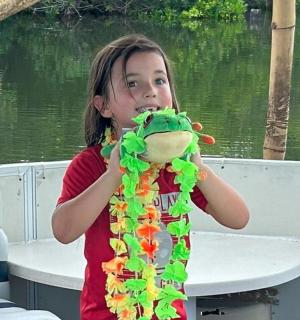 一个小女孩在船上抱着一只毛绒恐龙