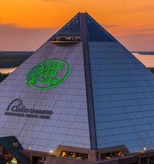 a pyramid shaped building with a sunset in the background