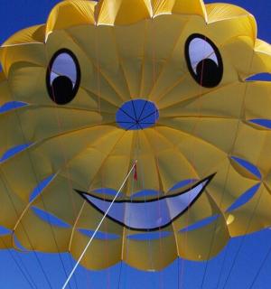 天空中一只画着脸的黄色风筝