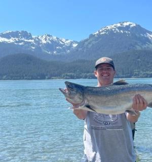 一名男子在水体前抱着一条鱼