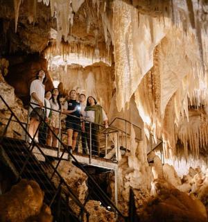 a group of people standing on a staircase in a cave