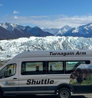 a white van parked in front of a snow covered mountain
