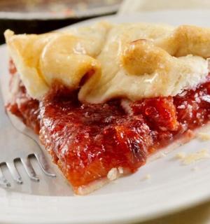 kus koláče na bílém talíři s vidličkou