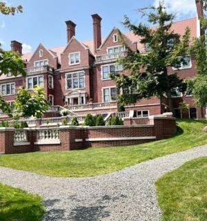 vnější pohled na velký cihlový dům se zahradou