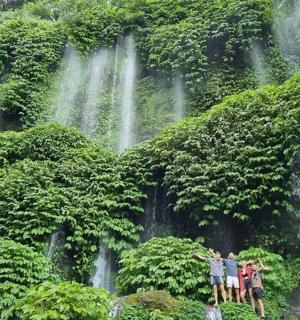 a group of people standing in front of a waterfall