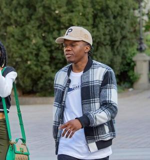 一名女子用相机给一名男子拍照