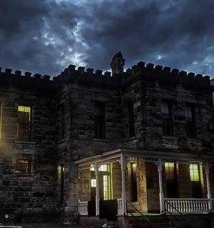 an old stone house with its lights on
