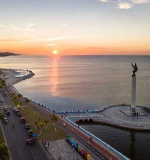 a view of a beach with the sun setting over the water