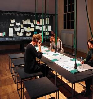 a group of people sitting at a table playing cards