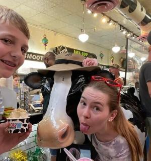 一个女孩站在商店里的牛雕像旁边