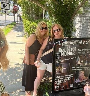 a group of women standing next to a sign