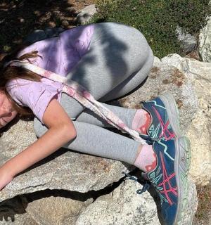 malá holčička leží na skále