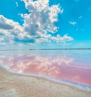 a beach with a cloudy sky and the water