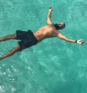 muž ležící ve vodě v oceánu