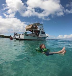 mladý chlapec plave ve vodě s loďkou