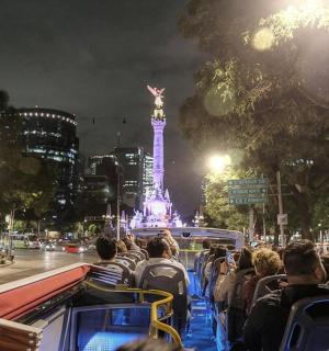 grupa ludzi jadąca autobusem ulicą miasta