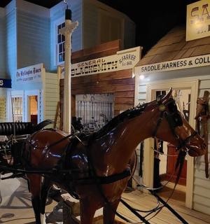 socha koně táhnoucího kočár před obchodem