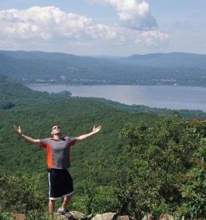 a man standing on top of a mountain with his arms outstretched