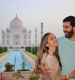 a man and a woman standing in front of the taj mahal