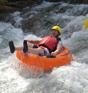 muž v oranžovém voru v řece