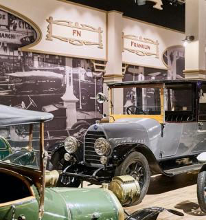 a group of old cars on display in a museum