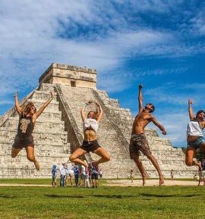 eine Gruppe von Menschen, die vor einer Pyramide springen